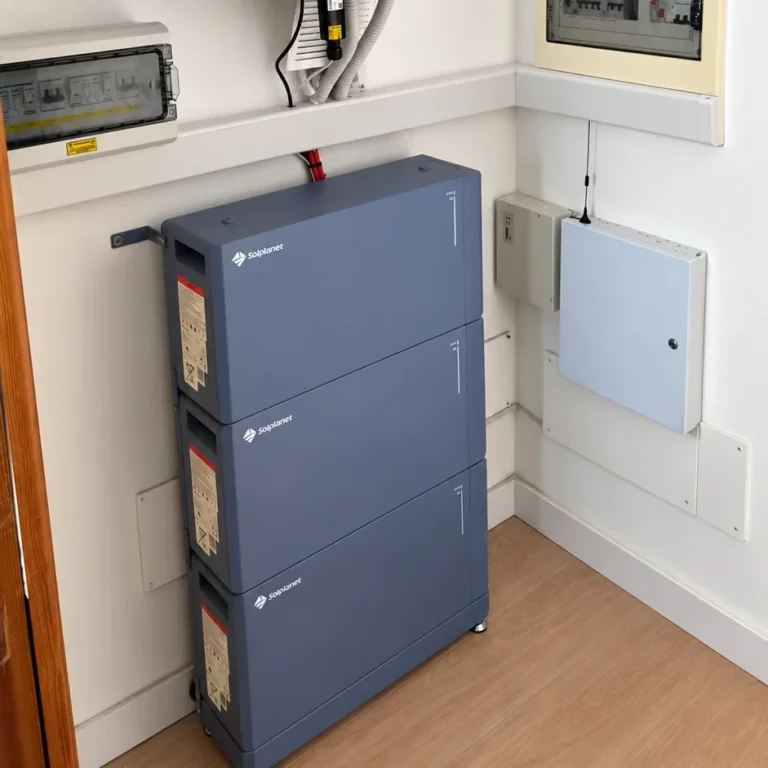 Tres módulos de batería apilados y fijados a la pared de una vivienda, junto al cuadro eléctrico